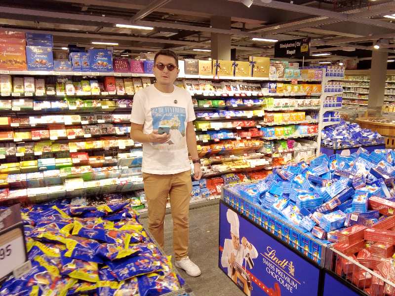 Homem em pé dentro da maior loja da Lindt do mundo