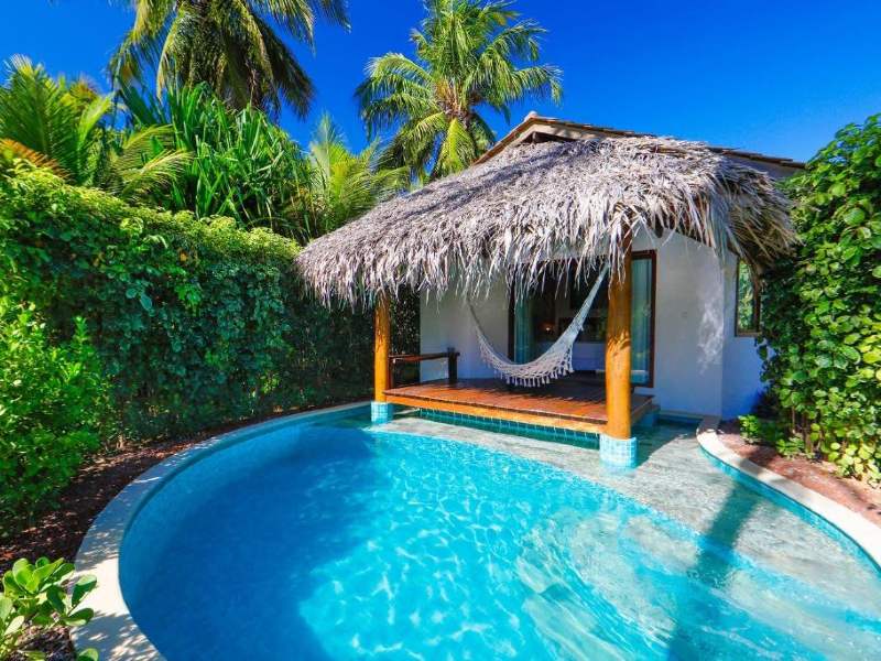 Piscina e rede de acomodação da Samba Pa Ti, dica entre as pousadas na Praia do Patacho, em dia de céu azul