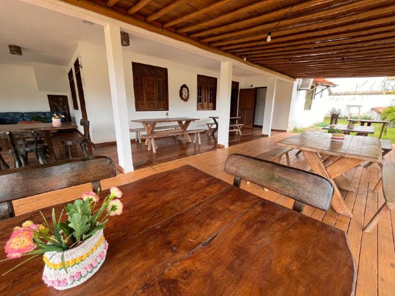 Área comum da Pousada Sunshine com grandes mesas de madeira