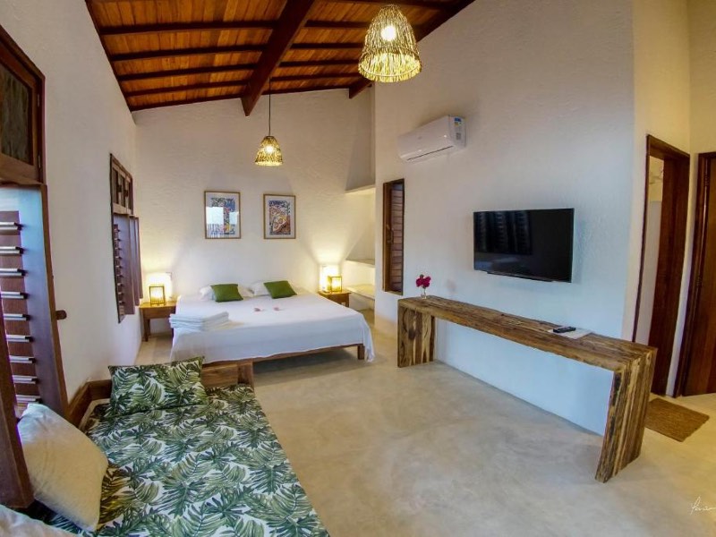 Quarto da Toca do Caranguejo, dica entre as pousadas na Praia do Patacho, com cama de casal, TV e ar-condicionado