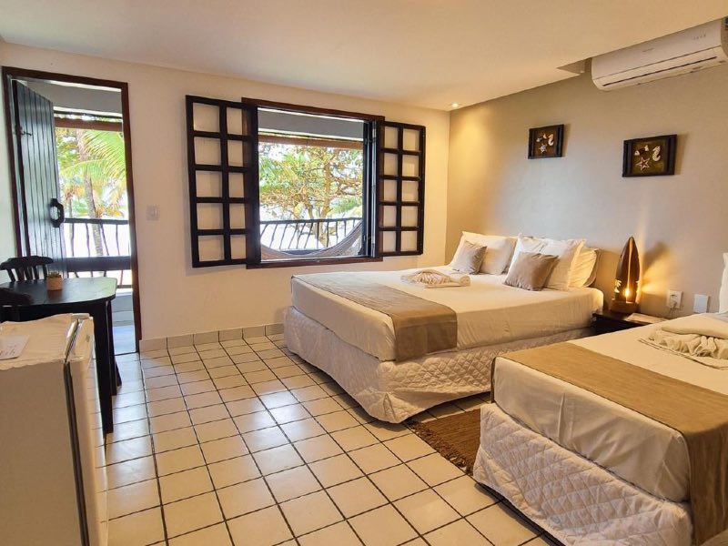 Quarto da Pousada dos Coqueiros, dica de onde ficar em Maracaípe, com cama de casal e de solteiro, ar-condicionado e frigobar