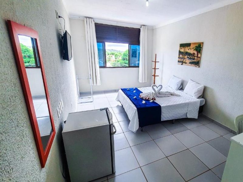 Quarto simples da pousada Sal e Mar com cama de casal, TV e frigobar