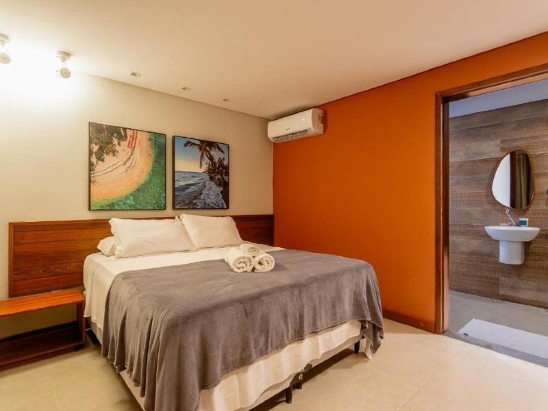 Quarto da Un Paso del Mar, dica de pousada em Maracaípe, com cama de casal, quadros na parede e ar-condicionado