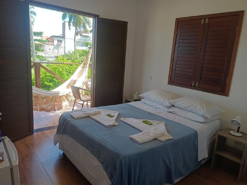 Quarto da Vila dos Santos com cama de casal e varanda com rede