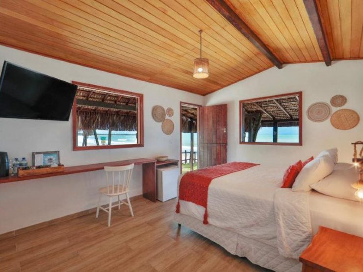 Quarto espaçoso da Xalés com cama de casal, TV e frigobar
