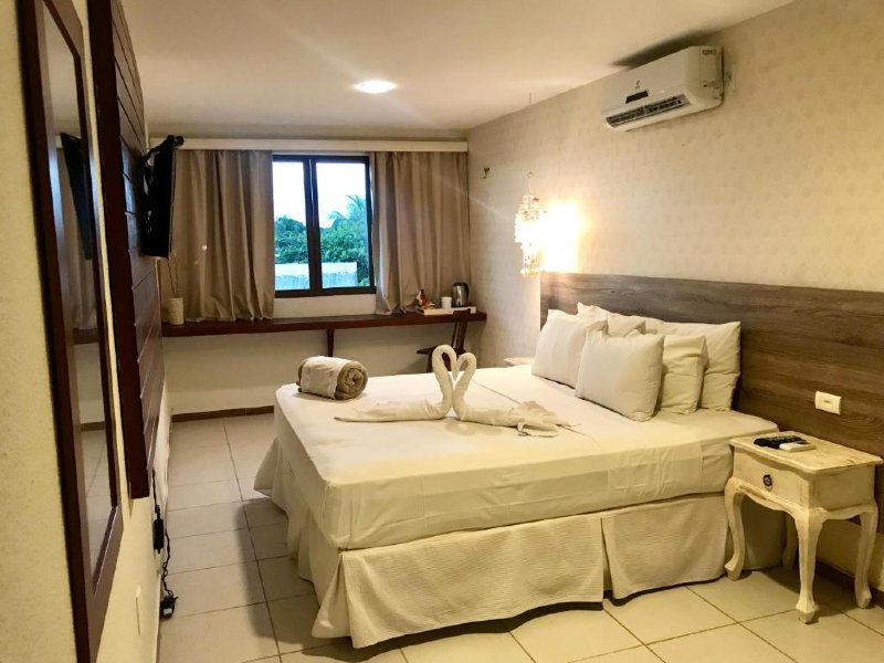 Quarto da Flor de Maraca com cama de casal, TV e ar-condicionado