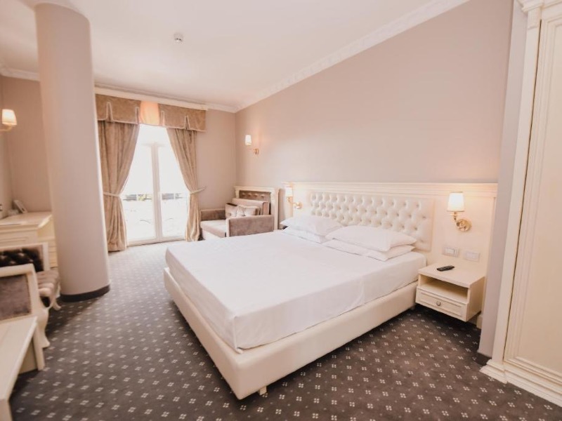 Quarto do Lot Boutique Hotel, dica de onde ficar em Tirana, com cama de casal, carpete e cortina