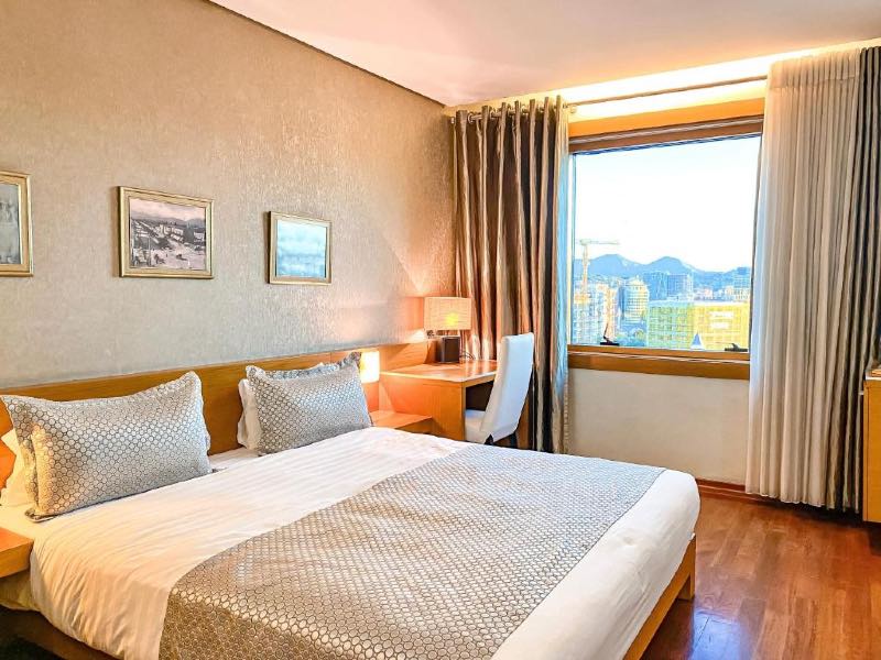 Quarto do Tirana International Hotel, dica de onde ficar em Tirana, com cama de casal e piso de madeira