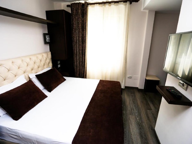 Quarto pequeno do Town House com cama de casal e decoração preta e branca