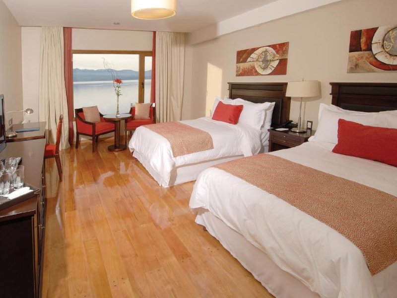 Quarto do Alma del Lago, dica de hotel em Bariloche, com duas camas, vista para o lago e piso de madeira