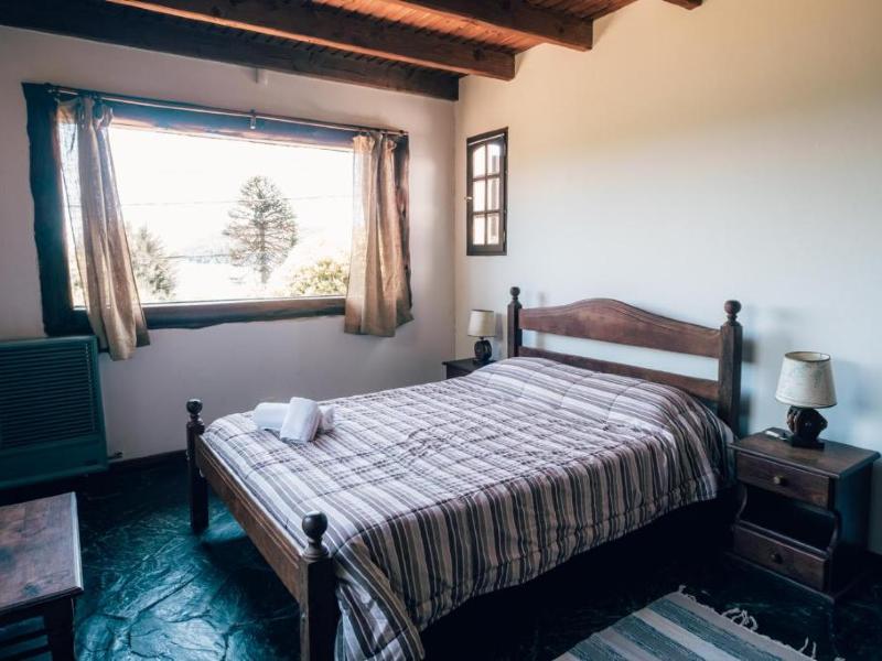 Quarto simples do Bonita Lake House com cama de casal e móveis de madeira
