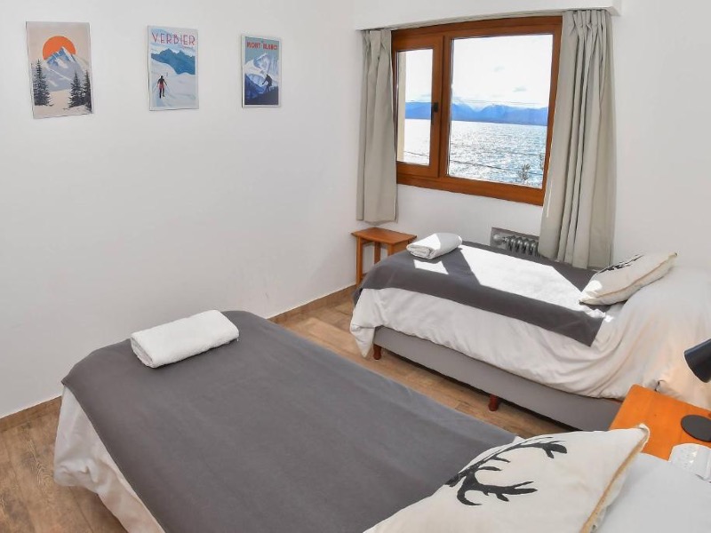 Quarto simples do Del Lago Sky Hotel com duas camas de solteiro e vista para o lago
