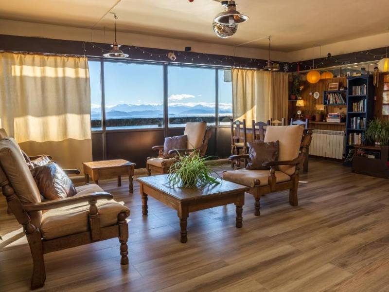 Área comum da Hospedaje Penthouse 1004 com poltronas, cadeiras e vista para o lago