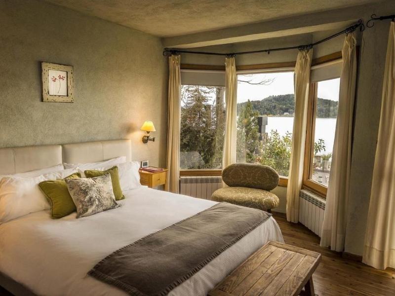 Quarto do Lirolay Suítes com cama de casal, vista para o lago e decoraçãp em tons pastéis