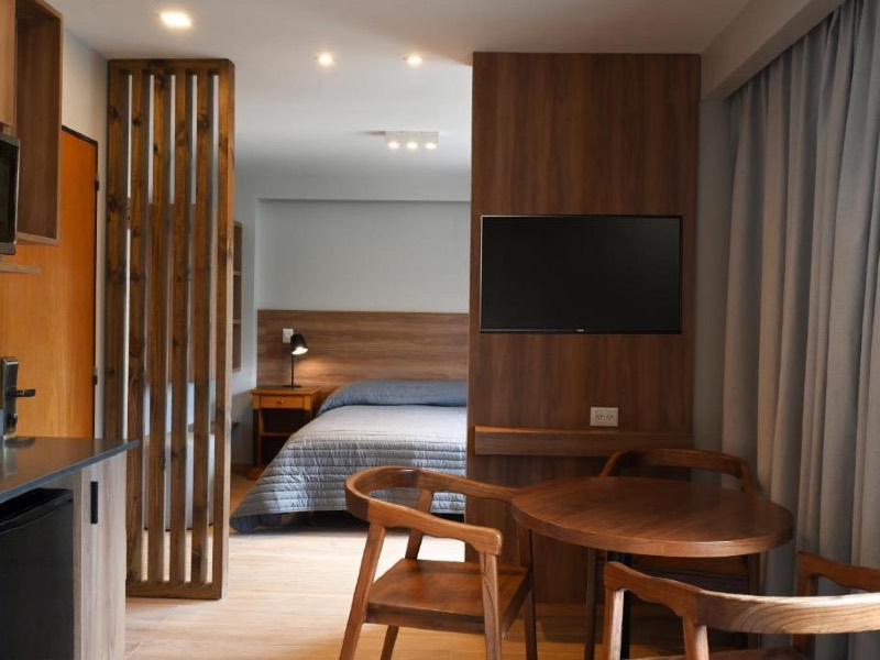 Quarto do Nevada, dica de hotel em Bariloche, com cama de casal, TV e mesa separada