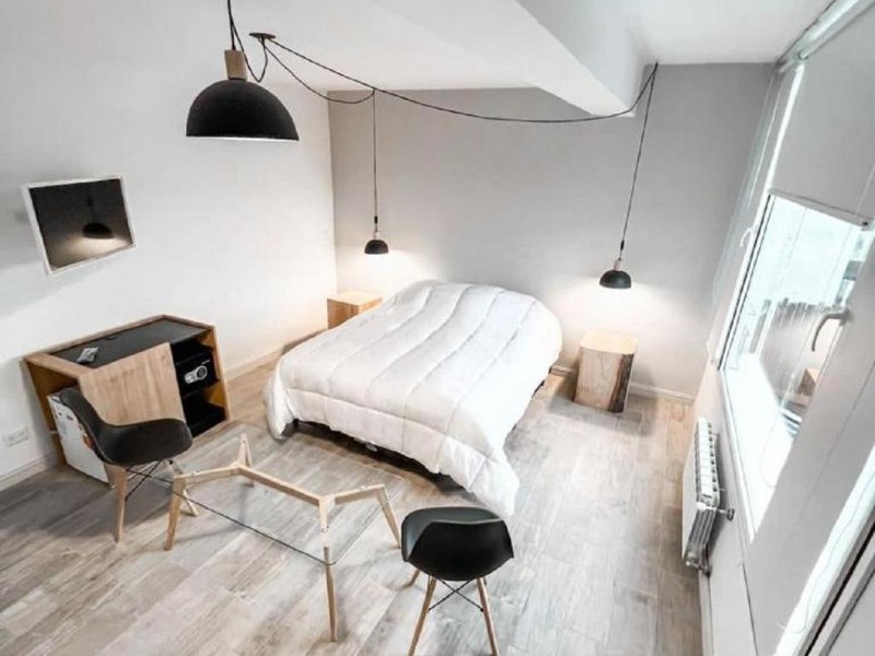 Quarto do Patagonia Signature com cama de casal, piso de madeira e decoração em tons de cinza, branco e preto