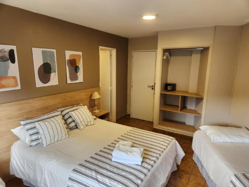 Quarto do Trip, dica de onde ficar em Bariloche, com cama de casal, cama de solteiro, armário, cofre e quadros na parede