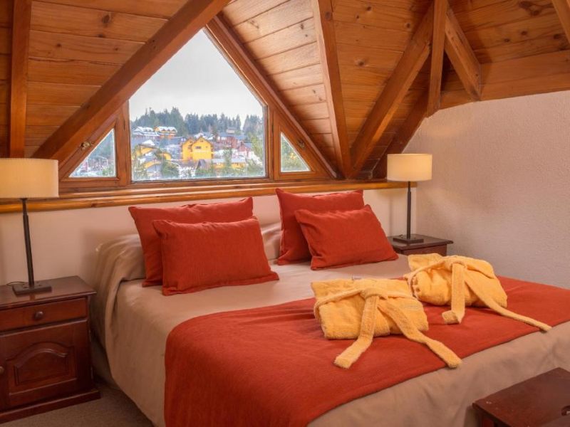 Quarto do Village Catedral com cama de casal e decoração em tons de terra