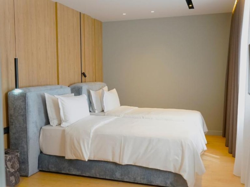 Quarto do Arbnor com cama de casal e piso e parede de madeira