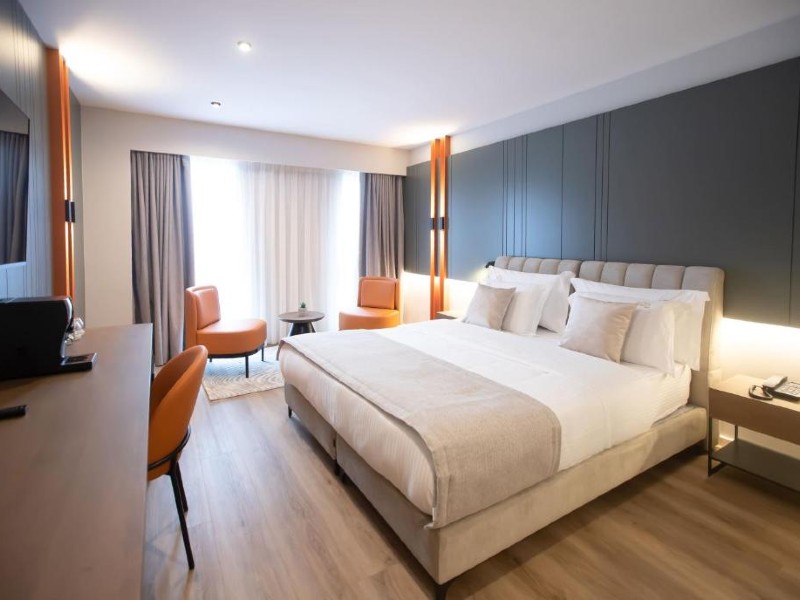 Quarto do Elisa Hotel, dica de onde ficar em Tirana, com cama de casal e piso de madeira