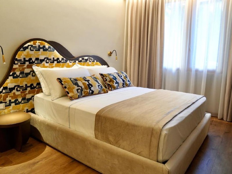 Quarto do Hortus com cama de casal e piso de madeira