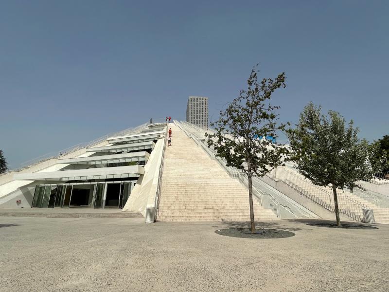 Pessoas subindo na Pirâmide de Tirana em dia de céu azul