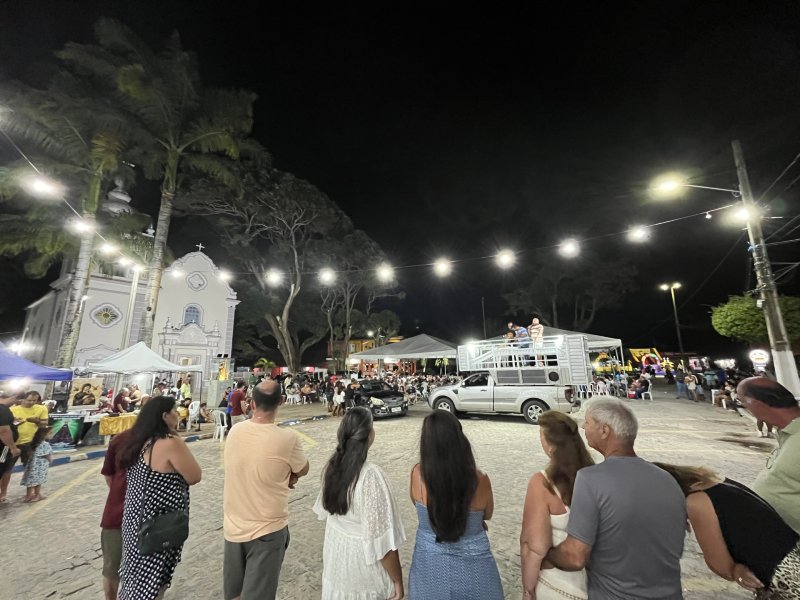 Pessoas em frente à igreja de São José, em Pernambuco, participam de bingo à noite