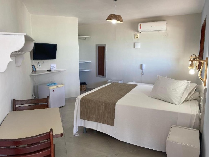 Quarto da Pousada Vivenda Oriente com cama de casal, TV e ar-condicionado