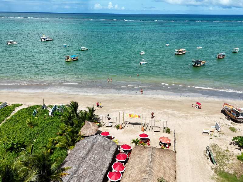 Praia do Centro, dica de o que fazer em São José da Coroa Grande, vista do alto com mar esverdeado e barcos