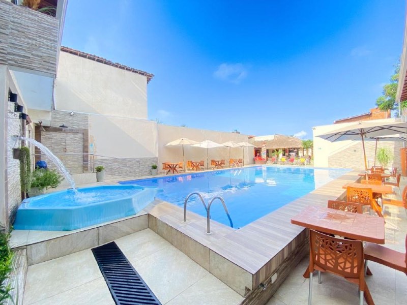 Área da piscina da pousada Villa Goya em dia de céu azul