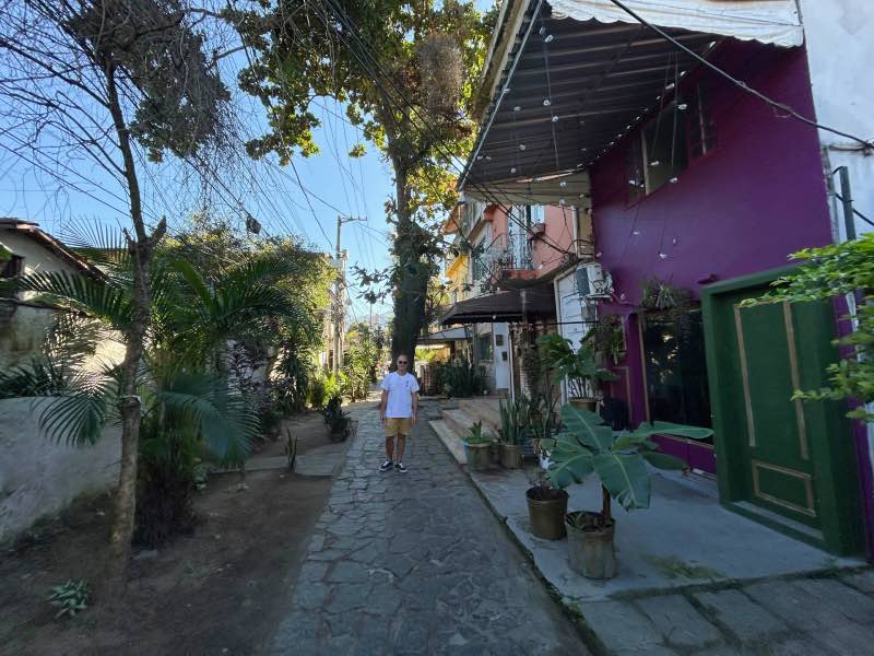 Rafael Carvalho passeia pelas vielas em ilha no Rio de Janeiro ao redor de árvores